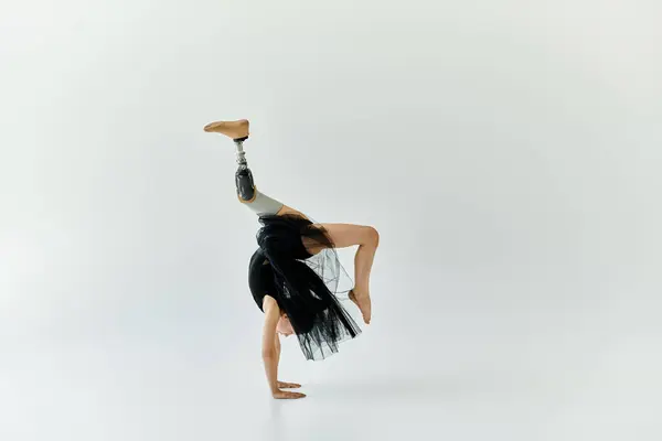 stock image A young girl with a prosthetic leg performs a handstand during a gymnastics routine.