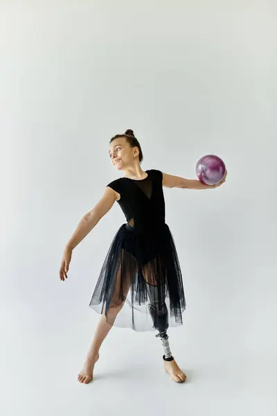 Stock image A young girl with a prosthetic leg practices gymnastics, showcasing her strength and grace.