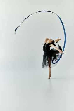 A young girl with a prosthetic leg performs a graceful gymnastics routine with a ribbon. clipart