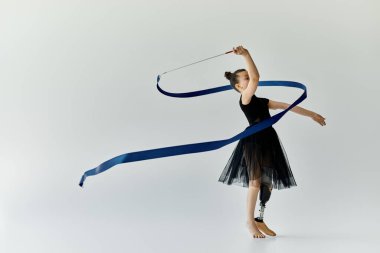 A young girl with a prosthetic leg gracefully performs a ribbon routine in a gymnastics studio. clipart