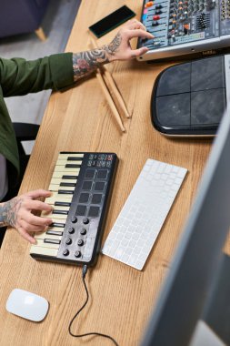 Müzik stüdyosunda MIDI klavye çalan yetenekli Asyalı bir adamın yakın plan görüntüsü..
