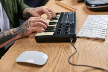 A close-up shot of an Asian mans hands playing a keyboard in a studio setting. clipart