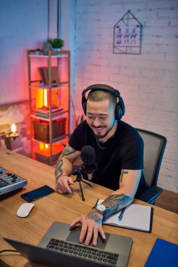 Dövmeleri olan yakışıklı bir Asyalı stüdyoda podcast yapıyor..