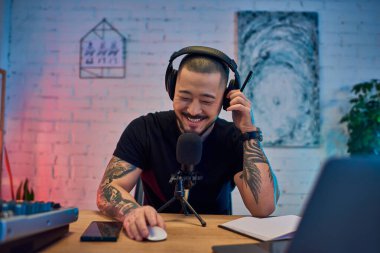 Yakışıklı bir Asyalı stüdyosunda oturmuş podcast kaydediyor..