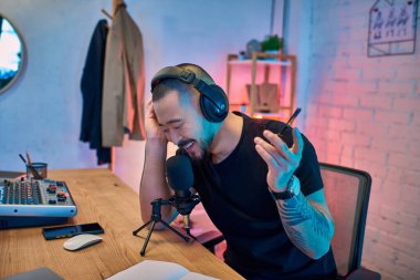 Yakışıklı bir Asyalı stüdyosunda bir podcast kaydediyor..