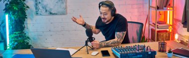Genç bir Asyalı kendi stüdyosunda bir podcast kaydediyor..