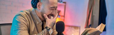Yakışıklı bir Asyalı stüdyoda podcast yaparken güler..