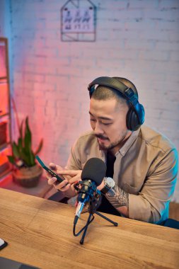 Yakışıklı bir Asyalı stüdyosunda bir podcast kaydediyor..