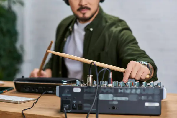 stock image A handsome Asian man plays drums in a studio, wearing casual clothing.