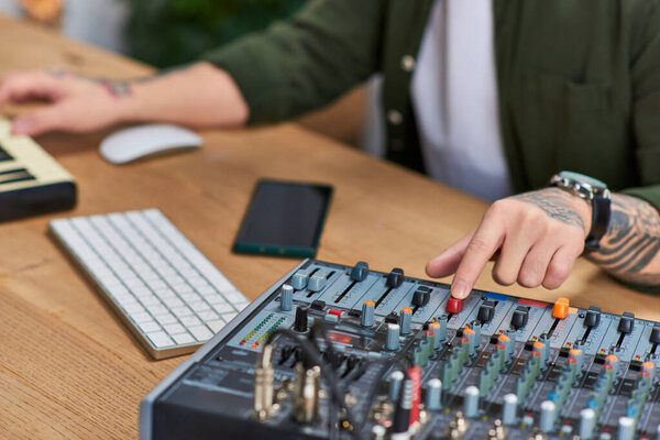 Молодой человек в студии работает на аудио-микшерском оборудовании.