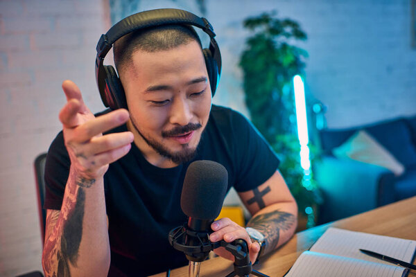 Молодой человек записывает подкаст в своей домашней студии.