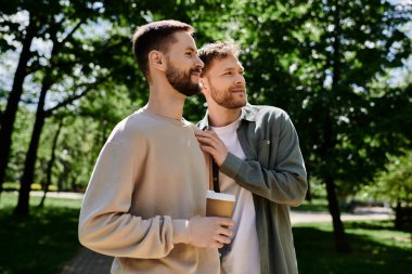 A gay couple with beards enjoy a coffee break in a green park, sharing a moment of love and intimacy. clipart