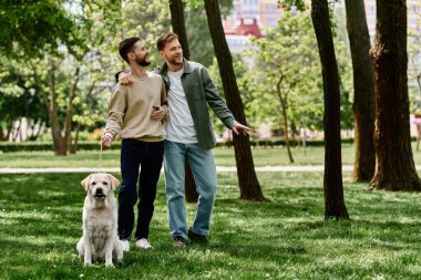 Sakallı eşcinsel bir çift yeşil bir parkta Labrador Retriever 'larıyla keyifli bir yürüyüş yapıyor..