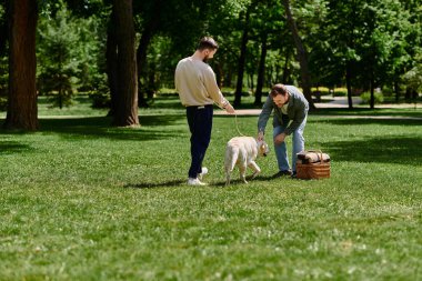 A gay couple with beards enjoys a sunny afternoon in a park with their labrador dog. clipart