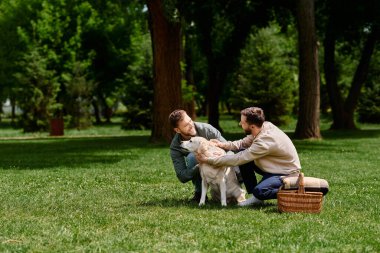 A happy gay couple plays with their labrador retriever in a grassy park, surrounded by trees. clipart