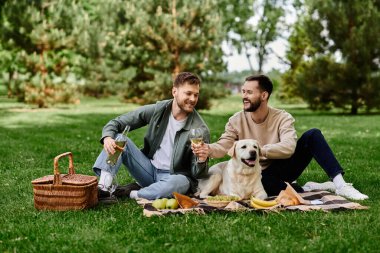 A bearded gay couple enjoys a picnic with their labrador retriever in a green park. clipart