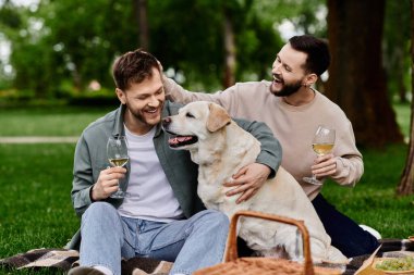 A bearded gay couple enjoys a sunny picnic with their labrador retriever in a green park. clipart