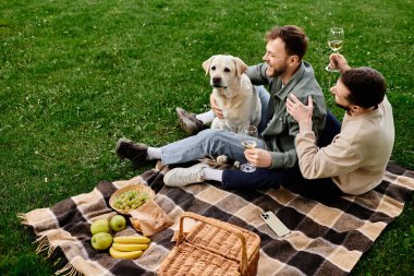 A gay couple enjoys a picnic with their labrador dog in a green park. clipart