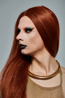 Ateşli kızıl saçlı ve cesur makyajlı bir drag diva şık bir elbise içinde poz verir..