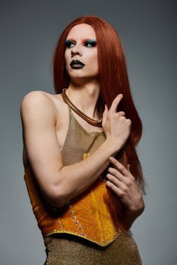 Altın korseli bir travesti fotoshoot için poz veriyor..