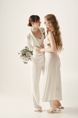 Two beautiful brides in white wedding attire embrace, sharing a tender moment on their special day. clipart