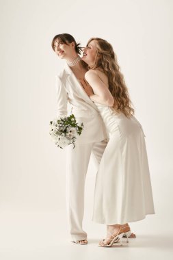 Beyaz elbiseli iki gelin düğün törenlerinde birbirlerine sarılırlar..