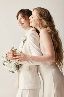 Beyaz elbiseli iki güzel gelin düğün günlerinde sevgi dolu bir anı paylaşıyor..