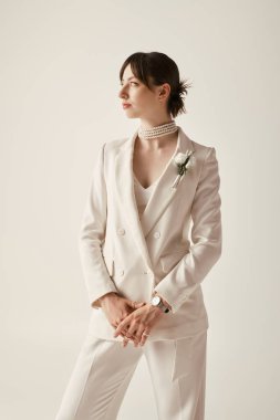 Çekici genç bir gelin şık beyaz bir ceket ve inci kolye ile poz veriyor, zarif tarzı büyüleyici..