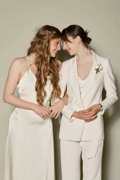 stock image A young lesbian couple, dressed in white, share a tender moment during their wedding ceremony.