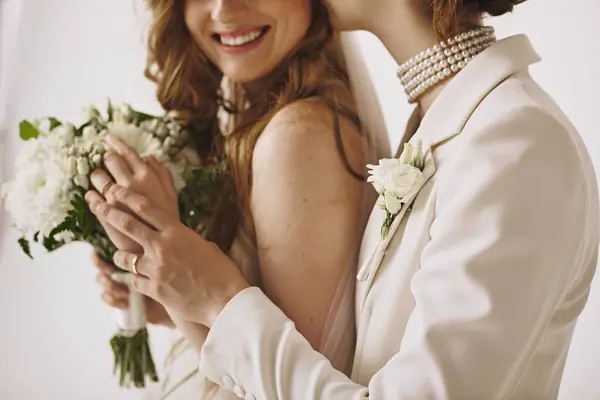 stock image Two brides in white wedding attire embrace during their ceremony, symbolizing their love and commitment.