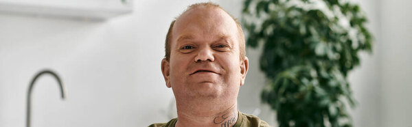 Человек с инклюзивностью сидит комфортно в своем доме, одетый в повседневную одежду.