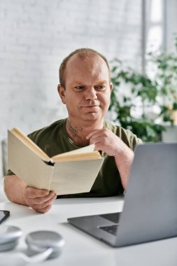 Kapsamlı bir adam evinde rahat ve rahat bir şekilde kitap okur..