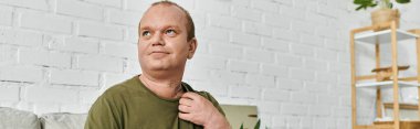Kapsayıcılığı olan bir adam evinde rahatlar, gömleğini ayarlar, günlük kıyafetlerini giyer..