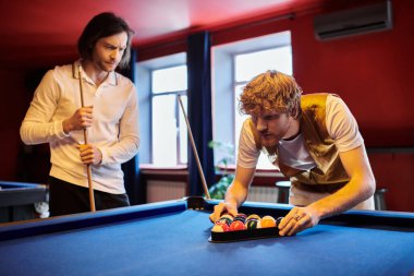 Arkadaşlar sıradan bir ortamda dostça bilardo oynarlar..