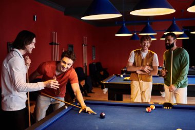 Arkadaşlar loş bir odada bilardo oynar, güler ve sıradan bir akşamın tadını çıkarırlar..