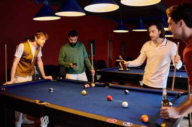 Arkadaşlar bir bilardo masasının etrafında toplanıp loş bir odada bilardo oynuyorlar..