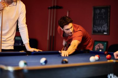 Friends play a game of billiards in a dimly lit room. clipart