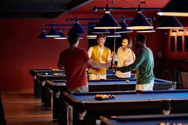 Arkadaşlar, kırmızı duvarları ve mavi keçeli masaları olan loş bir odada bilardo oynamaktan hoşlanırlar..