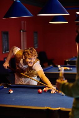 Arkadaşlar loş bir bilardo salonunda bilardo oynarlar..