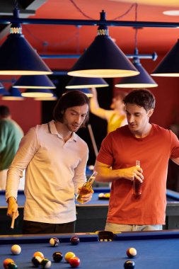Arkadaşlar loş bir ortamda bilardo oynarlar..