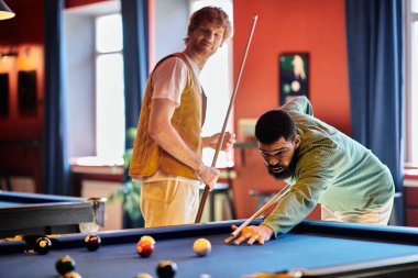 Arkadaşlar sıradan bir ortamda bilardo oynarlar..