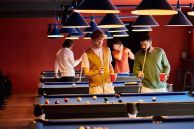 Arkadaşlar loş bir barda bilardo oynuyorlar, bir arkadaş ateş ediyor..