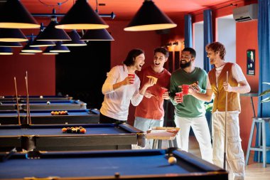Arkadaşlar loş bir bilardo salonunda bilardo masasının etrafında durup gülüp eğleniyorlar..
