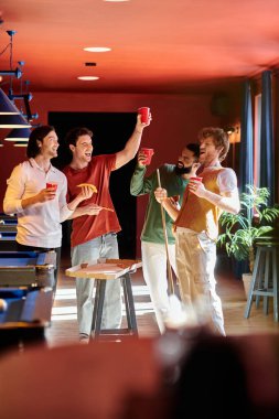 Friends stand in a billiard hall, laughing and celebrating after a game of billiards. clipart