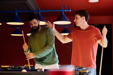 Arkadaşlar loş bir odada bilardo oynarlar..