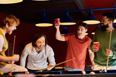 Arkadaşlar bir bilardo oyununun keyfini çıkarırlar, güler ve şutu kutlarlar..