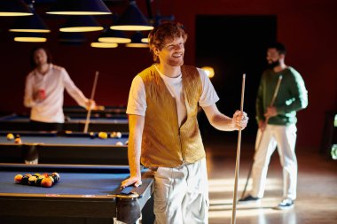 Arkadaşlar loş bir bilardo salonunda bilardo oynarlar..