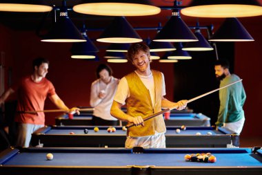Bir grup arkadaş loş bir bilardo salonunda bilardo oynuyorlar..