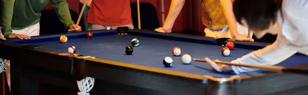 stock image Friends gather around a pool table, enjoying a casual game of billiards.