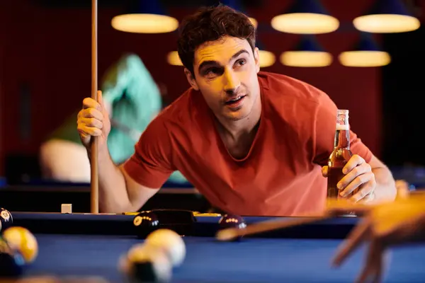 stock image A man concentrates on his shot while playing billiards with friends.